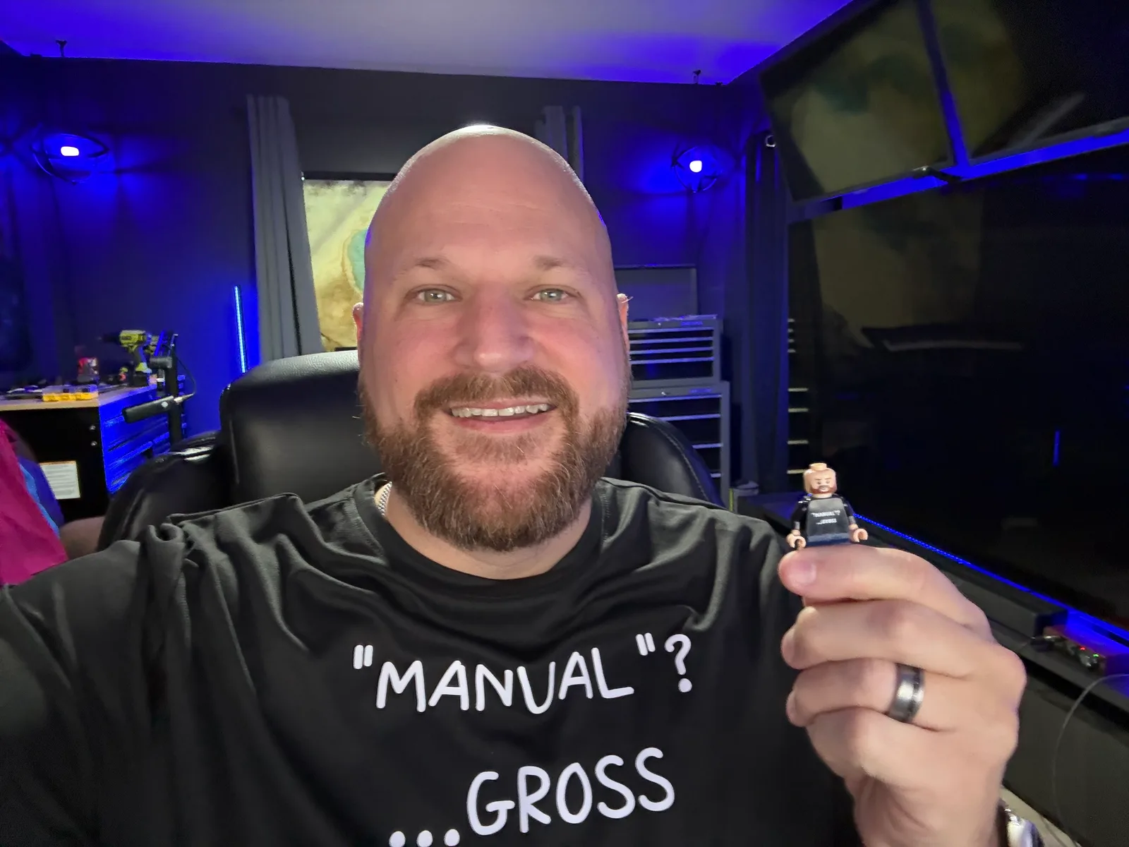 Jacob in his workshop wearing a shirt that reads Manual? Gross